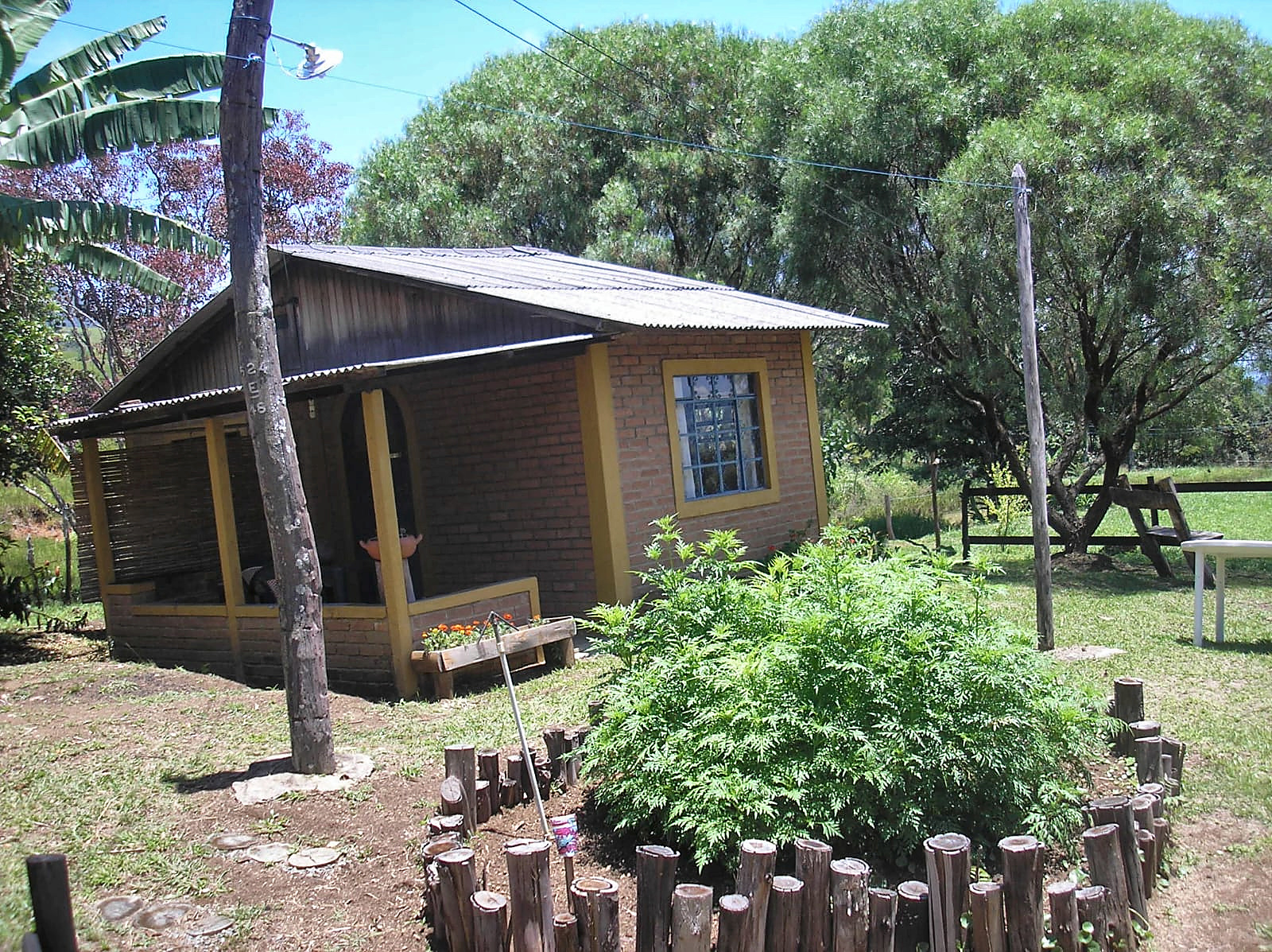 Cabana de madeira da Estalagem Pintassilgos vista pelo jardim